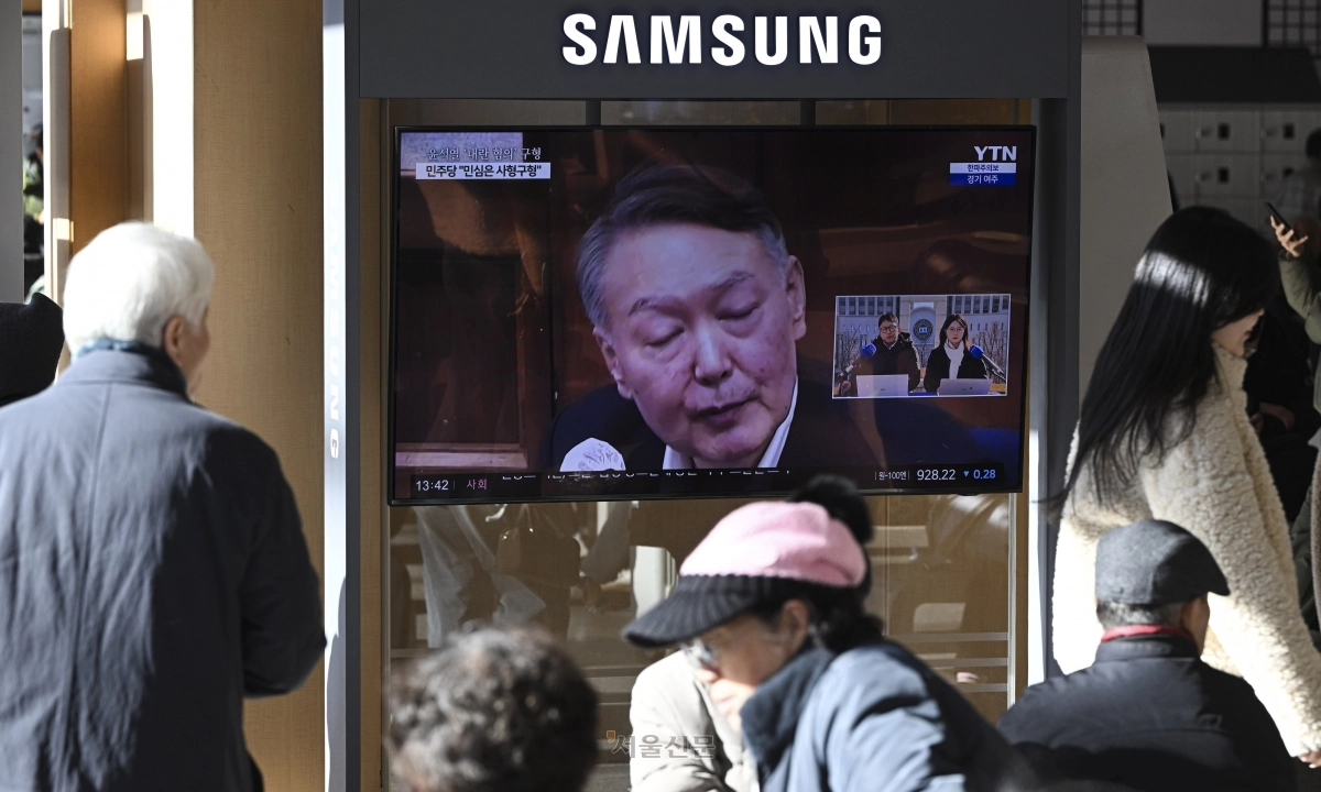 윤석열 전 대통령 내란 우두머리 혐의 결심공판이 열린 13일 서울역 대합실에서 시민들이 관련 뉴스를 시청하고 있다.  이지훈 기자