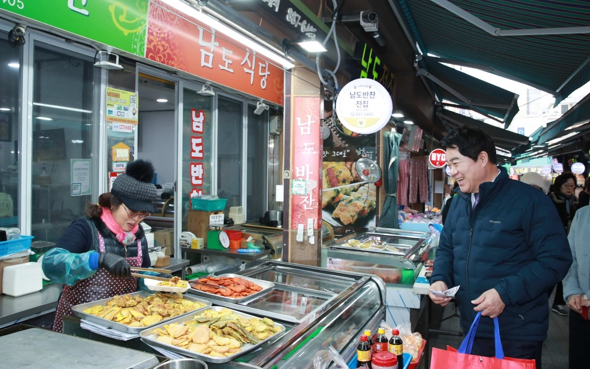 박준희(오른쪽) 관악구청장이 2024년 인헌시장에서 반찬을 구매하며 상인과 대화하고 있다. 관악구 제공