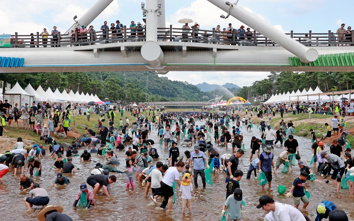 지난해 9월 열린 ‘2025 괴산고추축제’를 찾은 사람들이 동진천에서 물고기 잡기 체험을 즐기고 있다. 나흘간 열린 축제에는 31만 1000여명이 방문했다. 괴산군 제공