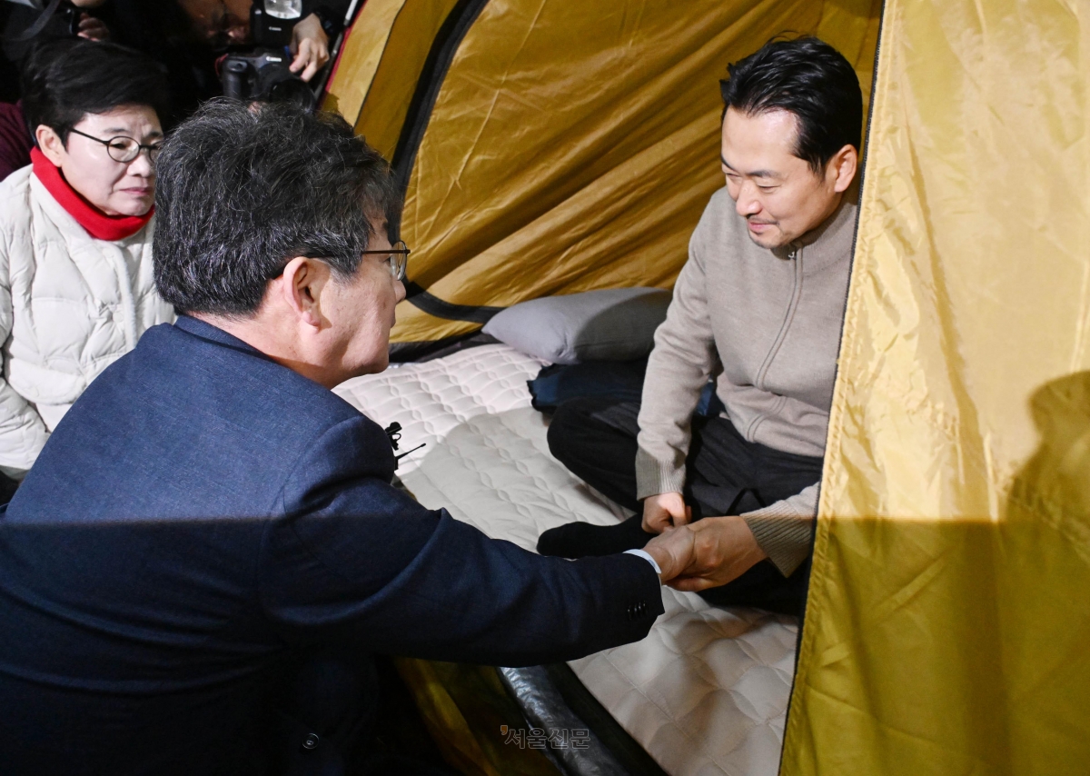 유승민(앞쪽) 전 의원이 20일 통일교·공천헌금 ‘쌍특검’ 수용을 요구하며 국회 로텐더홀에서 엿새째 단식 농성 중인 장동혁(오른쪽) 국민의힘 대표를 찾아가 이야기를 나누고 있다. 왼쪽은 임이자 국민의힘 의원. 안주영 전문기자