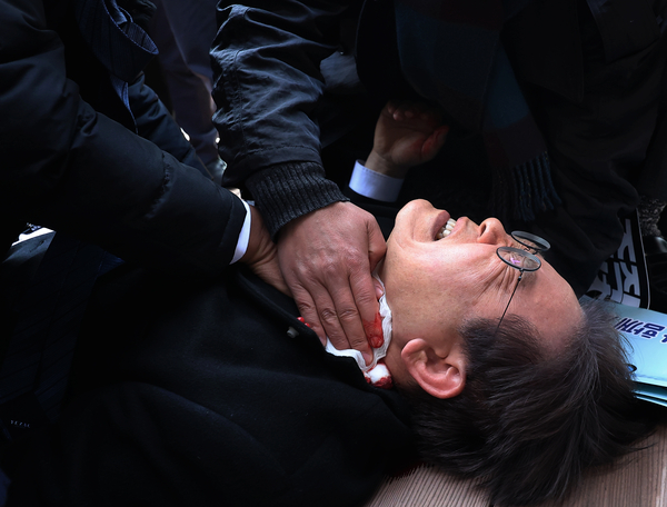 이재명 당시 더불어민주당 대표가 지난 2024년 1월 2일 부산 가덕도 신공항 부지를 둘러본 후 기자들과 문답을 진행하던 중 왼쪽 목 부위를 습격당해 피를 흘린 채 쓰러져 있다. 연합뉴스