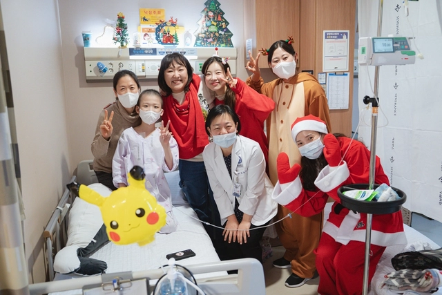 개그우먼 이수지(뒷줄 왼쪽 두번째)와 김아영(뒷줄 왼쪽 세번째)이 서울 세브란스병원을 찾아 소아 환자와 보호자, 의료진과 기념촬영을 하고 있다. 세브란스병원 제공