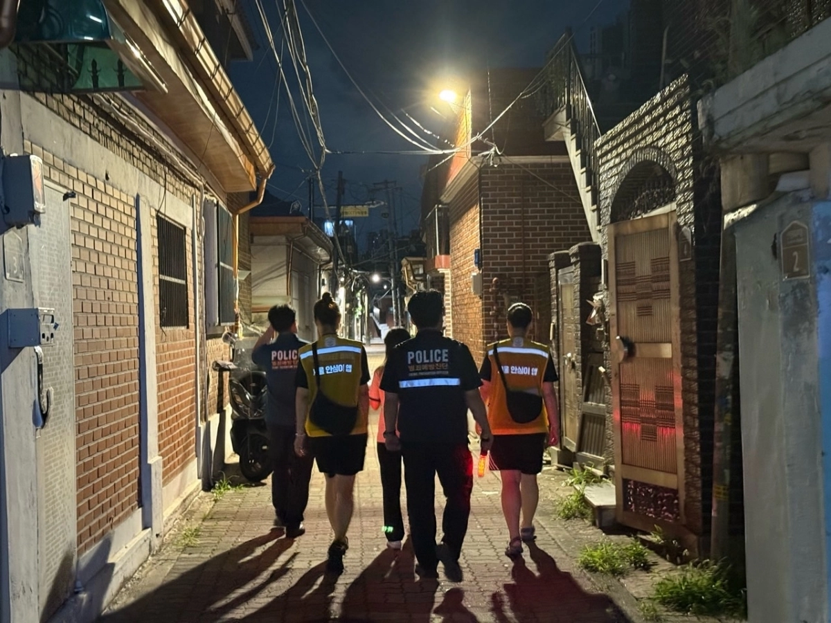 지난해 8월 동대문구 ‘안심 귀가 스카우트’ 단원과 범죄예방진단 경찰이 이문동 일대 골목을 순찰하고 있다. 동대문구 제공