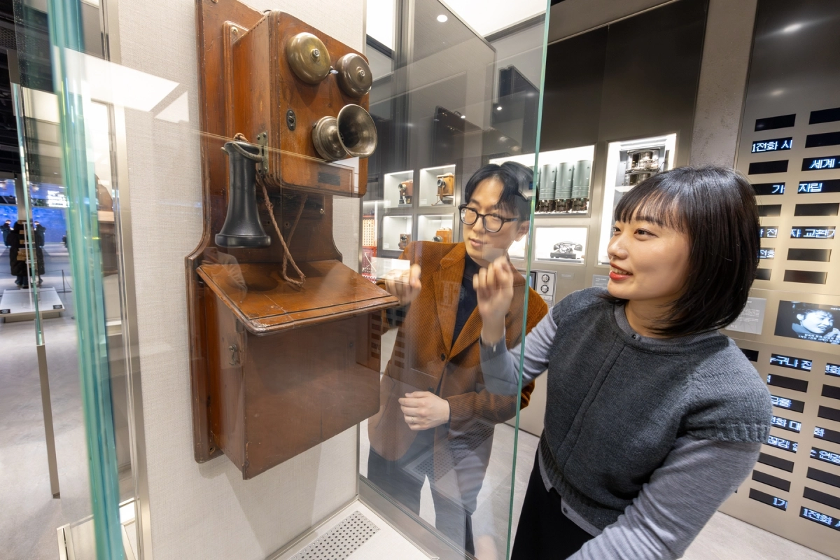 서울 종로구 KT 광화문빌딩 West 2층에 위치한 ‘온마루’에서 모델이 통신사료 전시 공간 ‘시간의 회랑’에 있는 초기 벽걸이형 전화기를 살펴보고 있다. KT 제공
