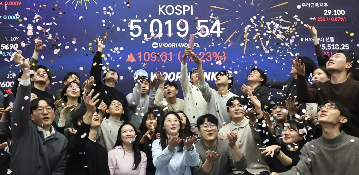 코스피 지수가 장중 사상 처음으로 5000을 넘어선 22일 서울 중구 우리은행 본점 딜링룸에서 딜러들이 축포를 터뜨리고 있다. 이날 코스피는 장중 5019.54를 기록한 뒤 4952.53에 마감했다. 연합뉴스