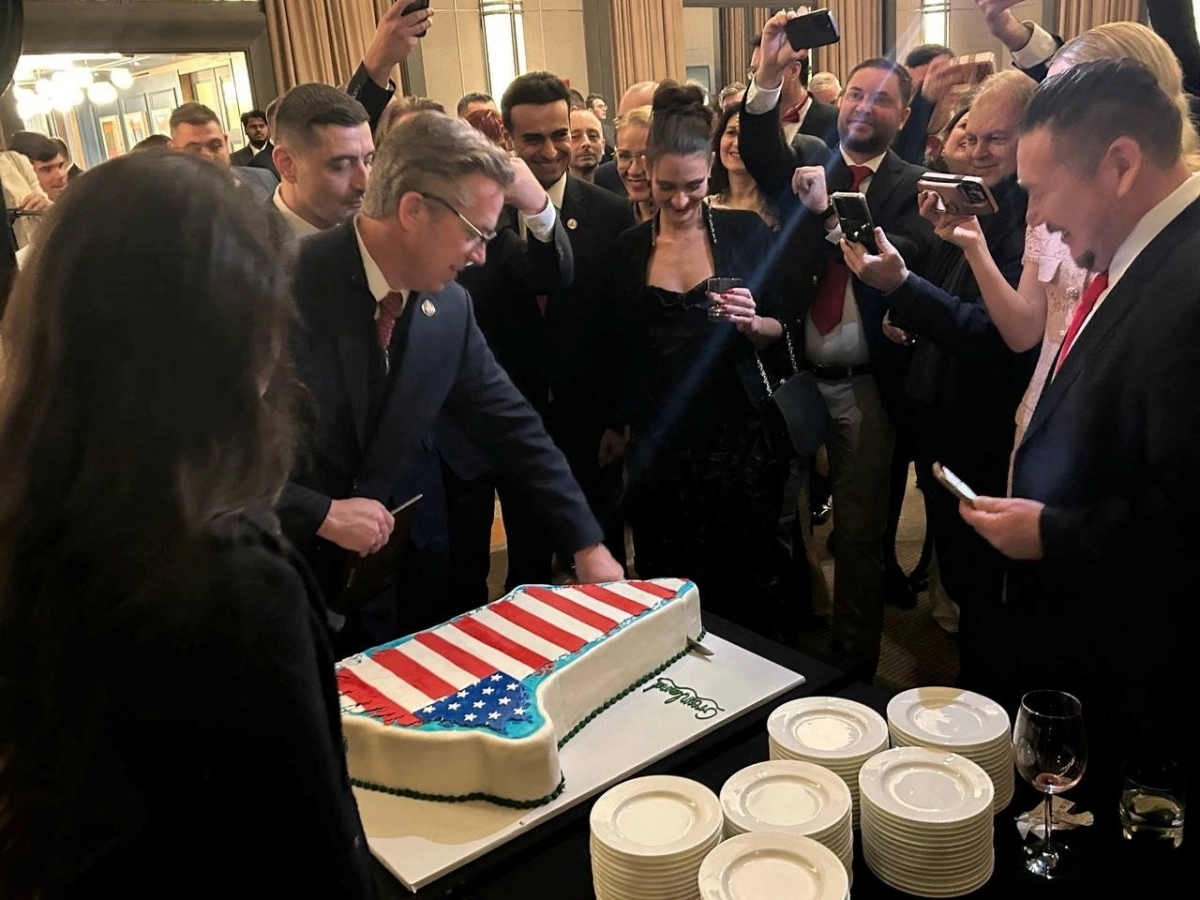 미국 워싱턴DC 케네디센터에서 지난 20일(현지시간) 도널드 트럼프 대통령의 취임 1주년을 기념해 열린 우파 단체 ‘국가 재건을 위한 공화당 모임’ 행사에서 참석자들이 성조기가 그려진 그린란드 모양의 케이크를 자르고 있다.  워싱턴DC 로이터 연합뉴스