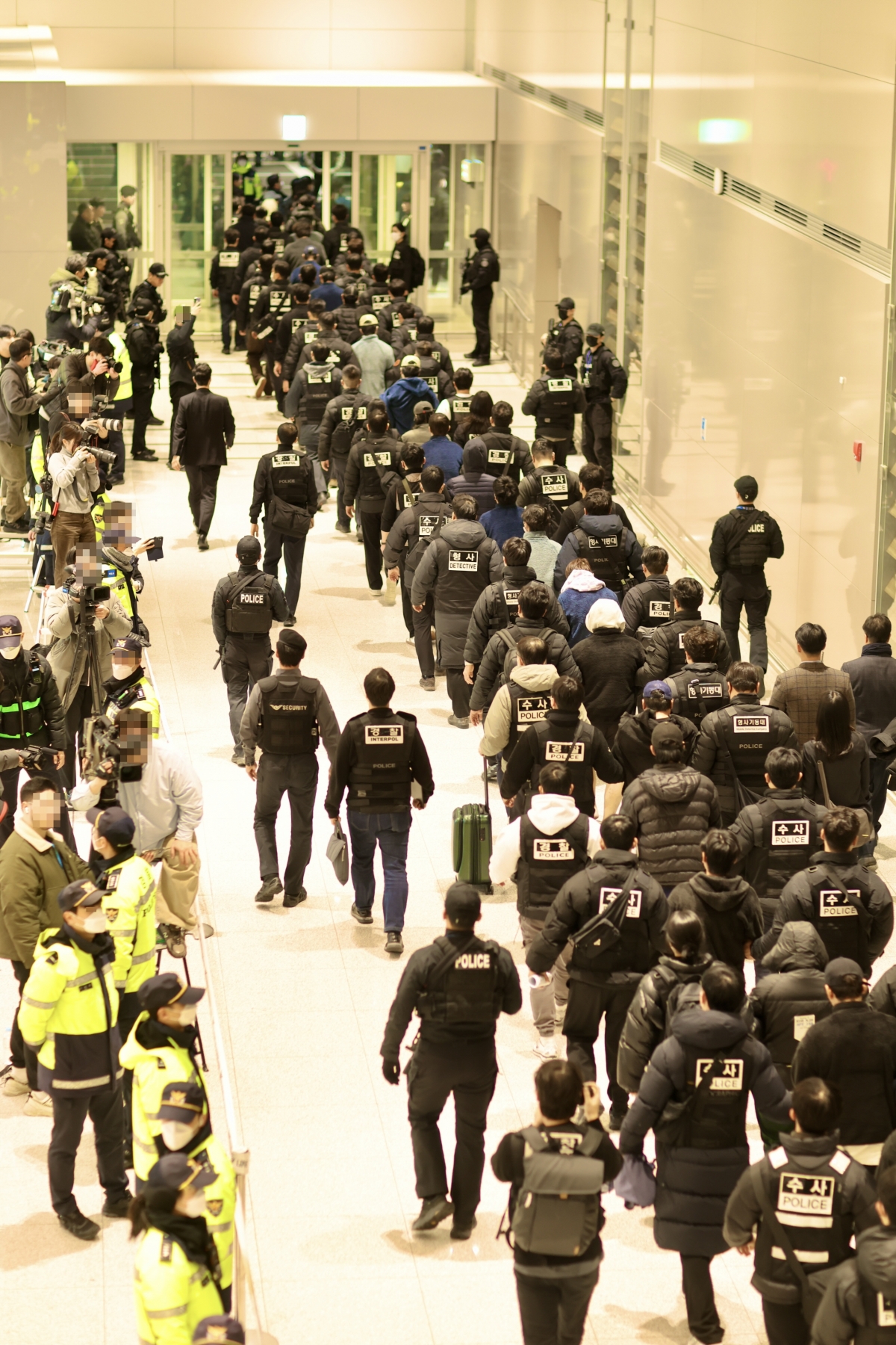 캄보디아에서 사기 등 범죄를 저지른 한국인 조직원들이 23일 인천공항으로 강제 송환돼 수사기관으로 압송되고 있다. 부산경찰청 제공