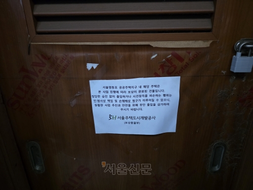지난 23일 서울 영등포구 쪽방촌에 위치한 한 쪽방의 정문에 서울주택도시공사(SH)의 보상 완료 안내 종이가 붙어있다. 김임훈 기자