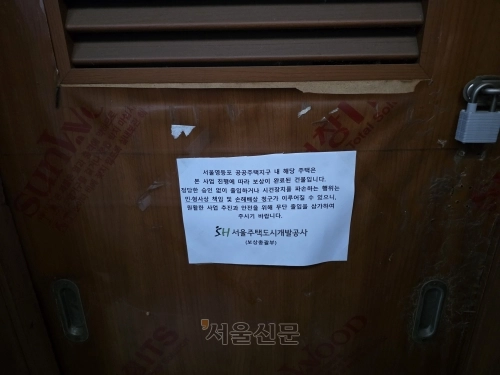 지난 23일 서울 영등포구 쪽방촌에 위치한 한 쪽방의 정문에 서울주택도시공사(SH)의 보상 완료 안내 종이가 붙어있다. 김임훈 기자