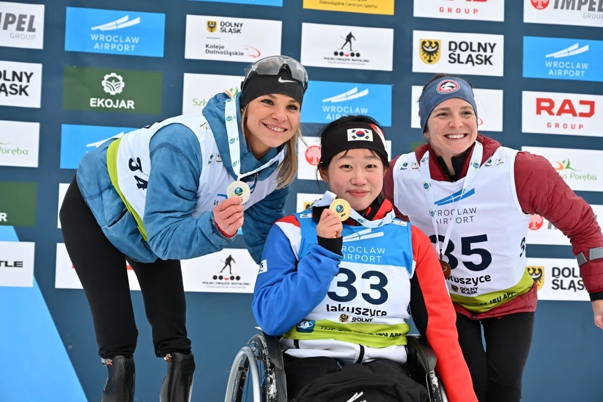 김윤지(가운데)가 24일(현지시간) 폴란드 야쿠시체에서 열린 2026 국제바이애슬론연맹(IBU) 파라 바이애슬론 월드컵에서 금메달을 손에 들고 각각 은메달과 동메달을 차지한 옥사나 매스터스(왼쪽), 켄달 그레치와 함께 기념사진을 찍고 있다. 대한장애인체육회 제공