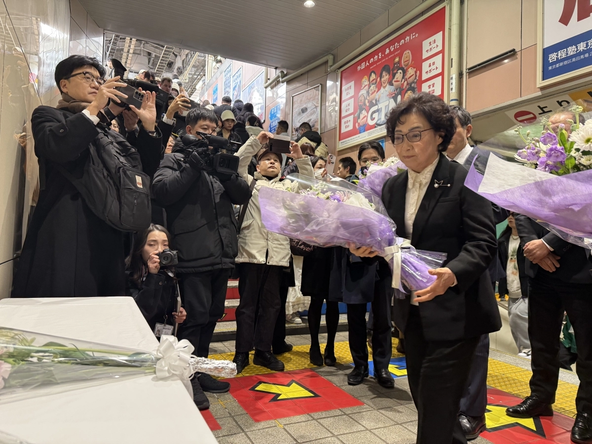 유학 시절 지하철 선로에 떨어진 일본인을 구하다 숨진 의인 이수현씨의 모친 신윤찬(오른쪽)씨가 26일 도쿄 신오쿠보역 계단 벽면에 새겨진 아들의 추모 동판에 헌화하고 있다. 주일한국대사관 제공
