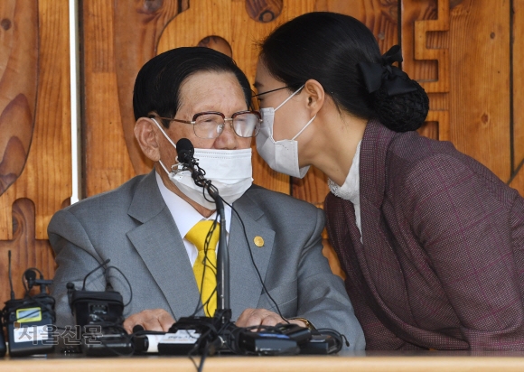 이만희(왼쪽) 신천지 총회장이 2020년 3월 2일 경기 가평군 신천지연수원에서 열린 코로나19 관련 기자회견에서 수행비서인 김모씨에게 귓속말로 질문을 전달받고 있다. 서울신문 DB