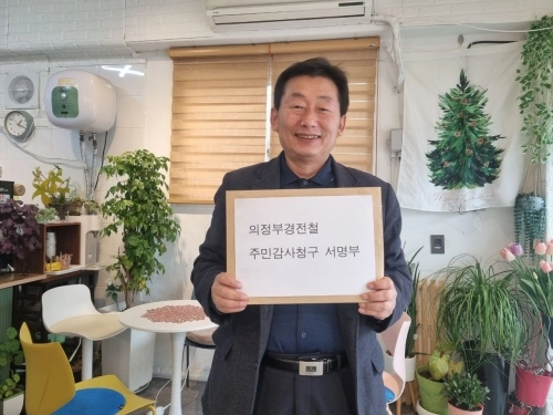 의정부경전철 주민감사청구 대표 임근재씨가 시민 서명부를 경기도에 발송하기에 앞서 사진을 찍고 있다.