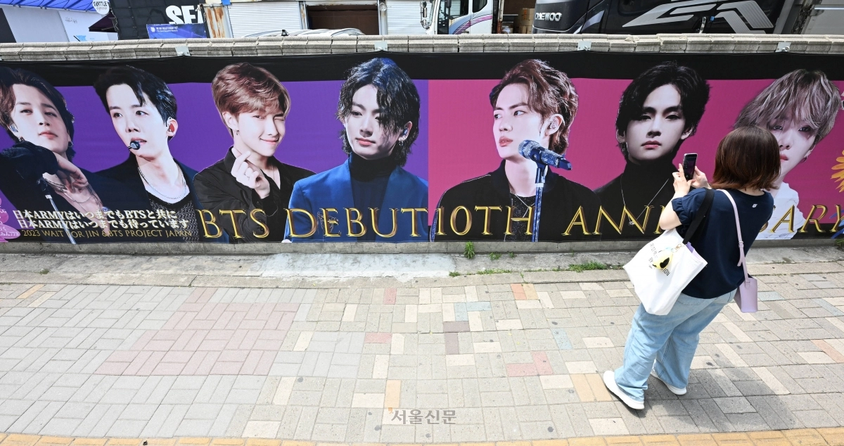 12일 오전 서울 용산구 하이브 사옥 인근에서 외국인 팬들이 방탄소년단(BTS) 데뷔 10주년 기념 그림 앞에서 사진을 찍고 있다. 2023.06.12. 도준석 기자
