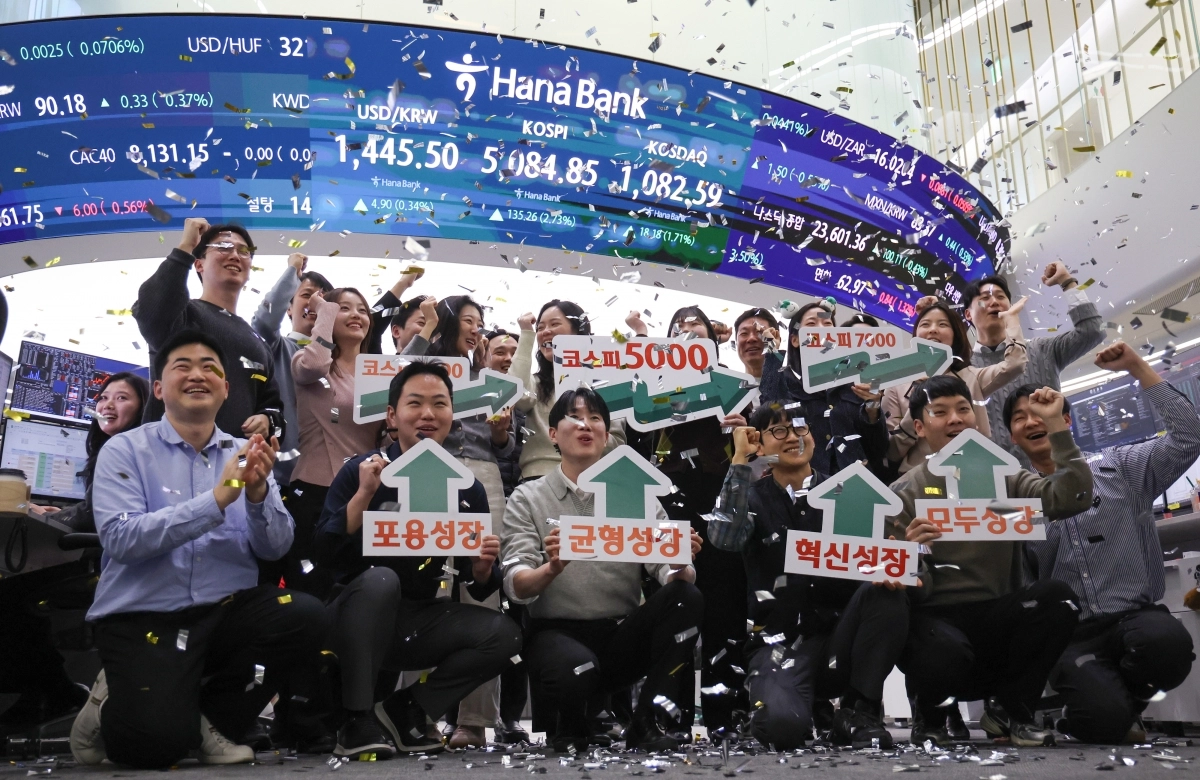 코스피지수가 종가 기준 5000선을 첫 돌파하고 코스닥도 1000선을 기록한 27일 서울 중구 하나은행 딜링룸에서 직원들이 기념 세레머니를 하고 있다. 연합뉴스