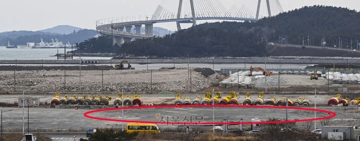 지난 26일 찾은 전남 목포신항 내 글로벌 풍력 터빈 제조사인 베스타스가 짓기로 한 풍력 터빈공장 부지(붉은색 원 안)가 텅 비어 있다. 베스타스는 이곳에 3000억원을 들여 풍력 터빈공장을 건설하기로 했지만, 1년 9개월째 진척이 없는 상황이다. 공장 부지 너머로 배후단지 및 항만 증설 공사가 진행되고 있다. 목포 이지훈 기자