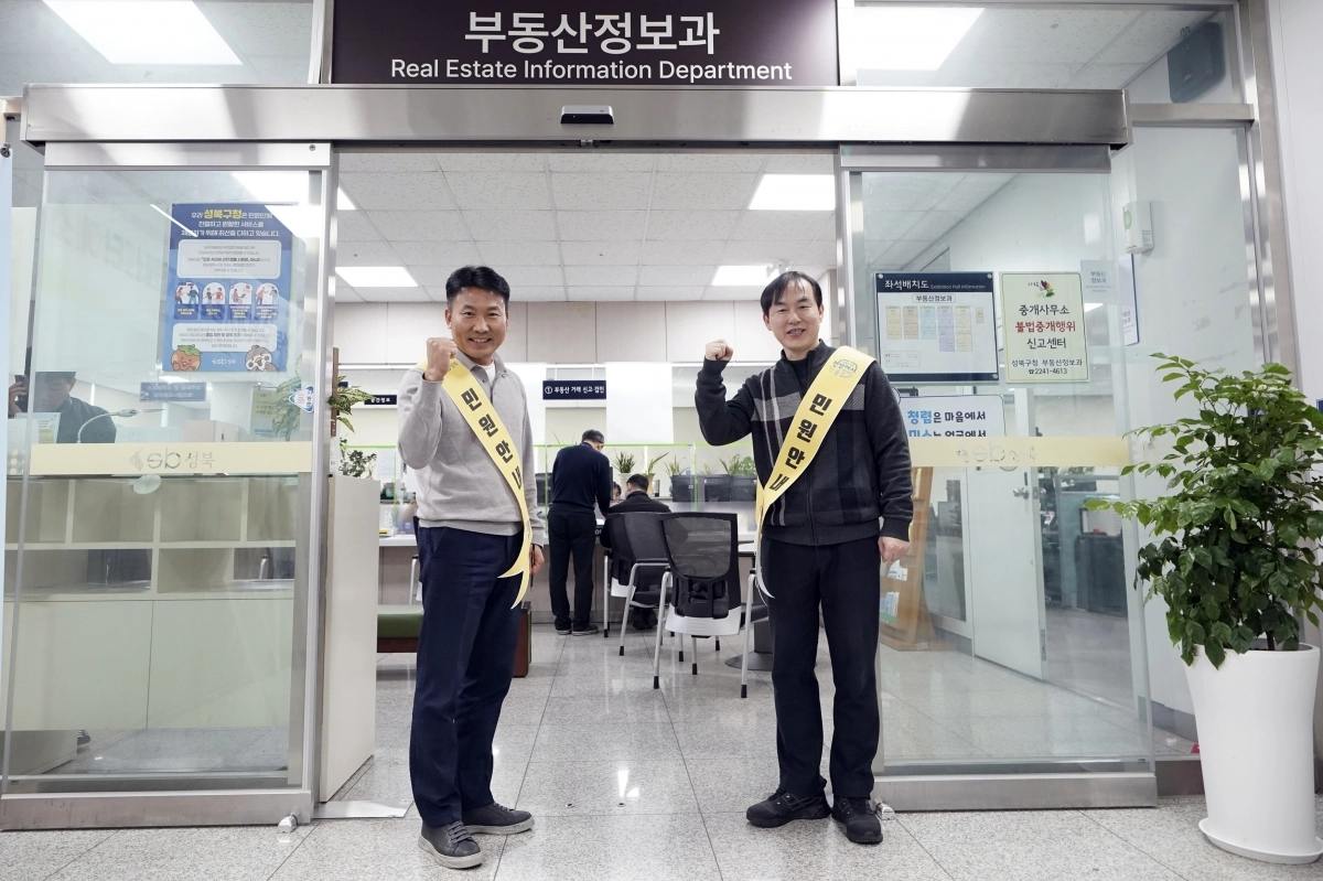 성북구청의 정기룡(왼쪽) 지적관리팀장과 서성호 공간정보팀장이 토지거래허가 신청 과정에서 어려움을 겪는 주민들을 돕기 위해 구청 민원실 허가신청 창구 앞에서 ‘민원도우미’로 활동하고 있다. 성북구 제공
