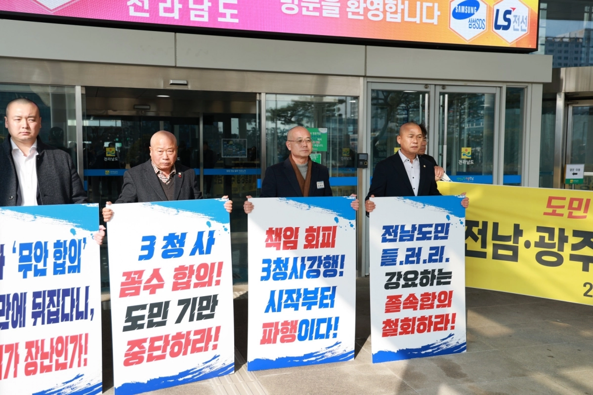 전남 무안군의회가 28일 전남도청 현관 앞에서 ‘전남광주특별시’ 3청사 꼼수 합의는 전남도민들을 기만하는 행위라며 피켓 시위를 벌이고 있다. (무안군의회 제공)