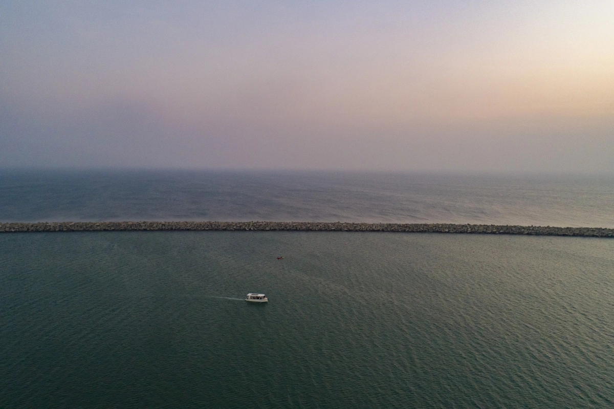 스리랑카 수도 콜롬보 앞 해변에서 한 여객선이 일몰을 향해 인도양을 가로지르고 있다.