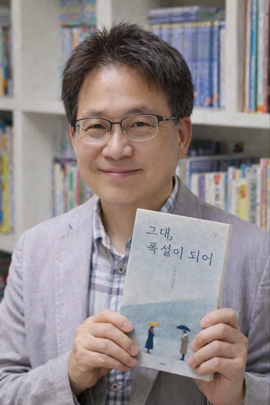 강병철(58) 법원 집행관이 사계절을 따라 사랑을 표현한 서정시 ‘그대, 폭설이 되어’ 시집을 들고 포즈를 취하고 있다.