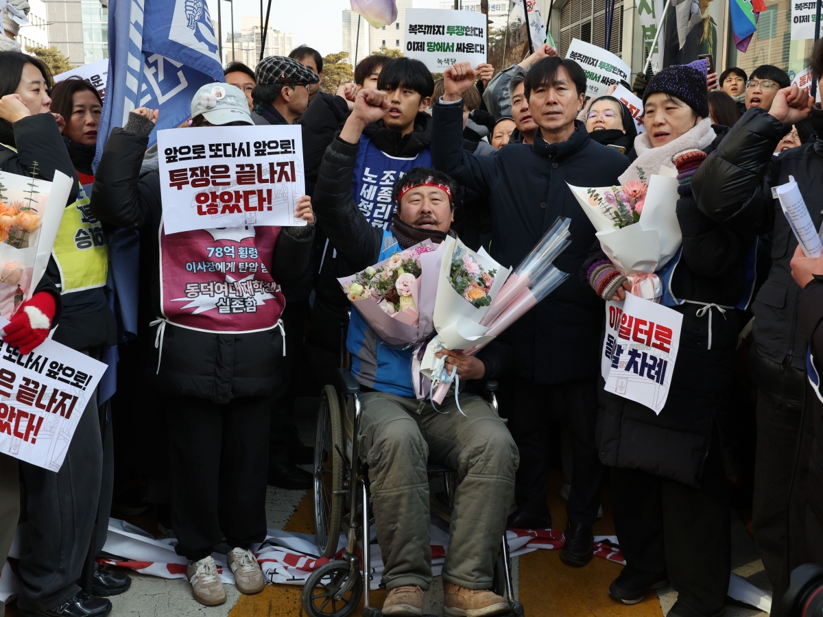 고진수 민주노총 서비스연맹 관광레저산업노조 세종호텔지부장이 14일 서울 중구 세종호텔 앞 구조물에서 내려온 뒤 휠체어에 앉아 구호를 외치고 있다. 연합뉴스