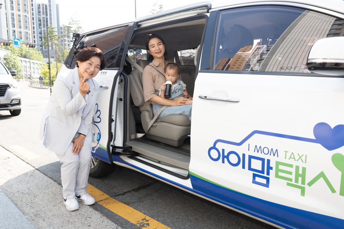 김미경(왼쪽) 은평구청장이 2024년 6월 응암동 거리에서 아이맘 택시에 탑승한 가족과 함께 활짝 웃고 있다. 은평구 제공