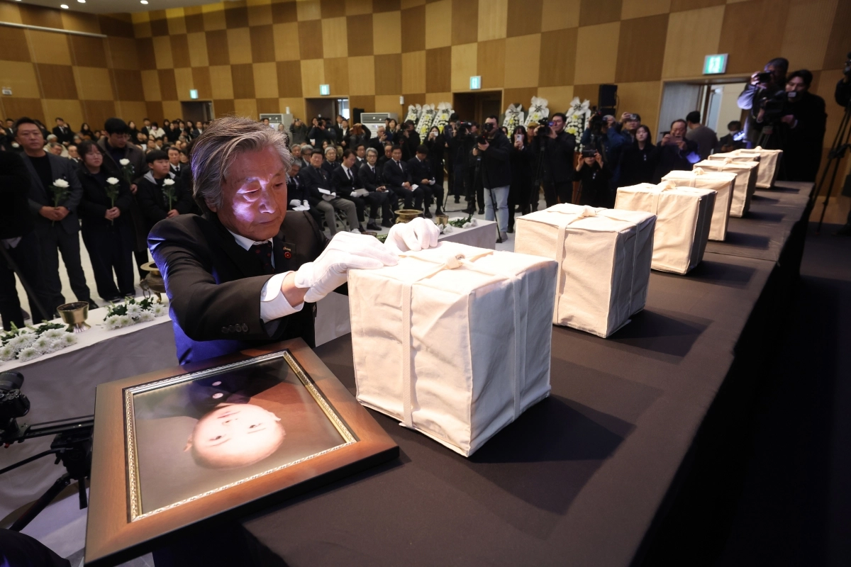 제주4·3 희생자의 한 유족이 3일 제주시 봉개동 제주4·3평화공원 평화교육센터에서 열린 ‘2025년 4·3 희생자 신원확인 보고회’에서 유해함에 이름표를 붙이고 있다. 제주 연합뉴스