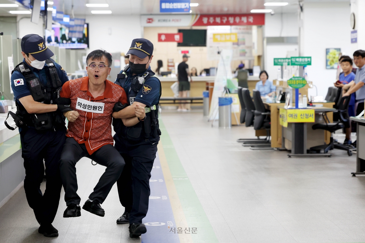 지난해 8월 21일 광주 북구청 민원실에서 열린 폭언.폭행 등 위법행위 발생 비상 대비 모의훈련에서 공무방해자 출입제한·퇴거조치 상황 교육이 실시 되고 있다. 광주 북구 제공