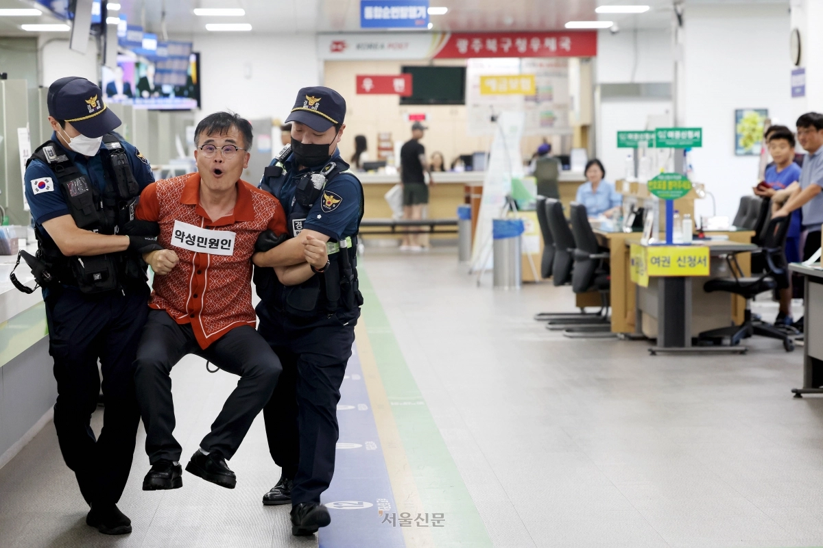 지난해 8월 21일 광주 북구청 민원실에서 열린 폭언.폭행 등 위법행위 발생 비상 대비 모의훈련에서 공무방해자 출입제한·퇴거조치 상황 교육이 실시 되고 있다. 광주 북구 제공