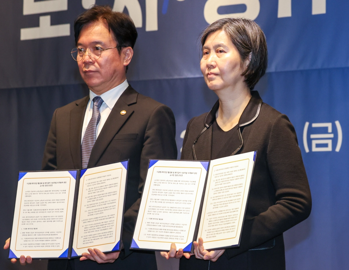 김영훈(왼쪽) 고용노동부 장관과 장지연 퇴직연금 기능 강화를 위한 노사정 태스크포스(TF) 위원장이 지난 6일 서울 여의도 켄싱턴 호텔에서 ‘기금형 퇴직연금’ 도입안을 담은 노사정 TF 공동선언문을 든 채 기념촬영을하고 있다. 뉴스1