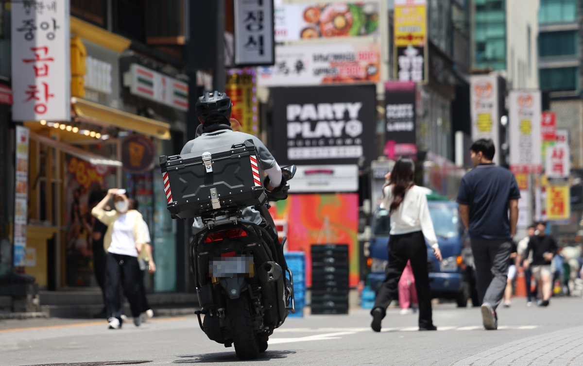서울 강남의 한 번화가에서 배달 라이더가 이동하고 있다.  연합뉴스