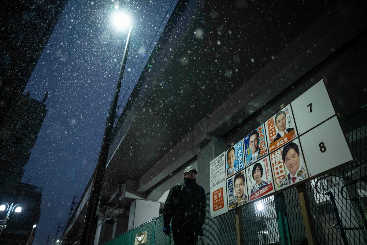 8일 가나가와현 가와사키에서 눈이 내리는 가운데 한 남성이 중의원 선거 후보들의 선거 포스터 옆을 지나가고 있다. 도쿄 AFP 연합뉴스