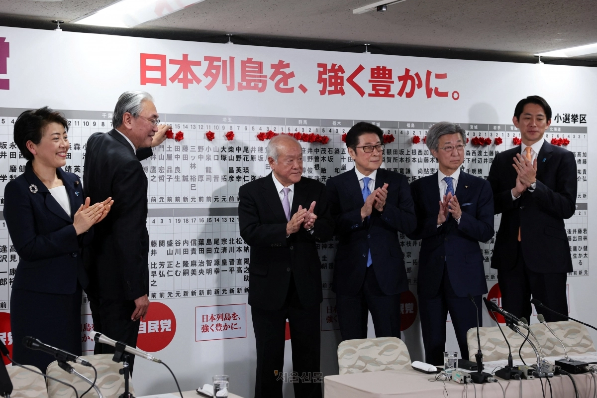 일본 집권 자민당 지도부가 8일 도쿄 자민당 본부 개표소에서 중의원 총선거 당선자의 이름 옆에 빨간 장미를 붙이고 있다. 스즈키 슌이치 간사장(오른쪽 세 번째)과 고바야시 다카유키(첫 번째) 정조회장 등이 참석했다. 도쿄 로이터 연합뉴스