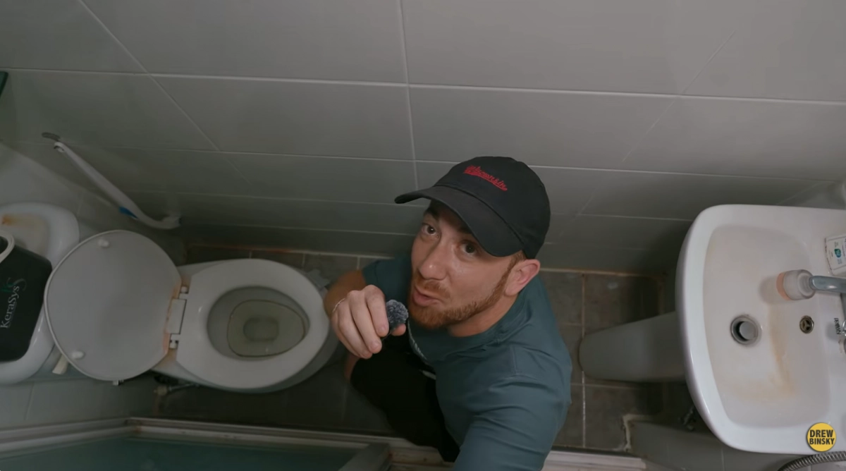 미국의 여행 유튜버 드류 빈스키가 서울 동작구의 한 고시원을 방문해 좁은 화장실을 둘러보고 있다. 유튜브 채널 ‘드류 빈스키’ 캡처