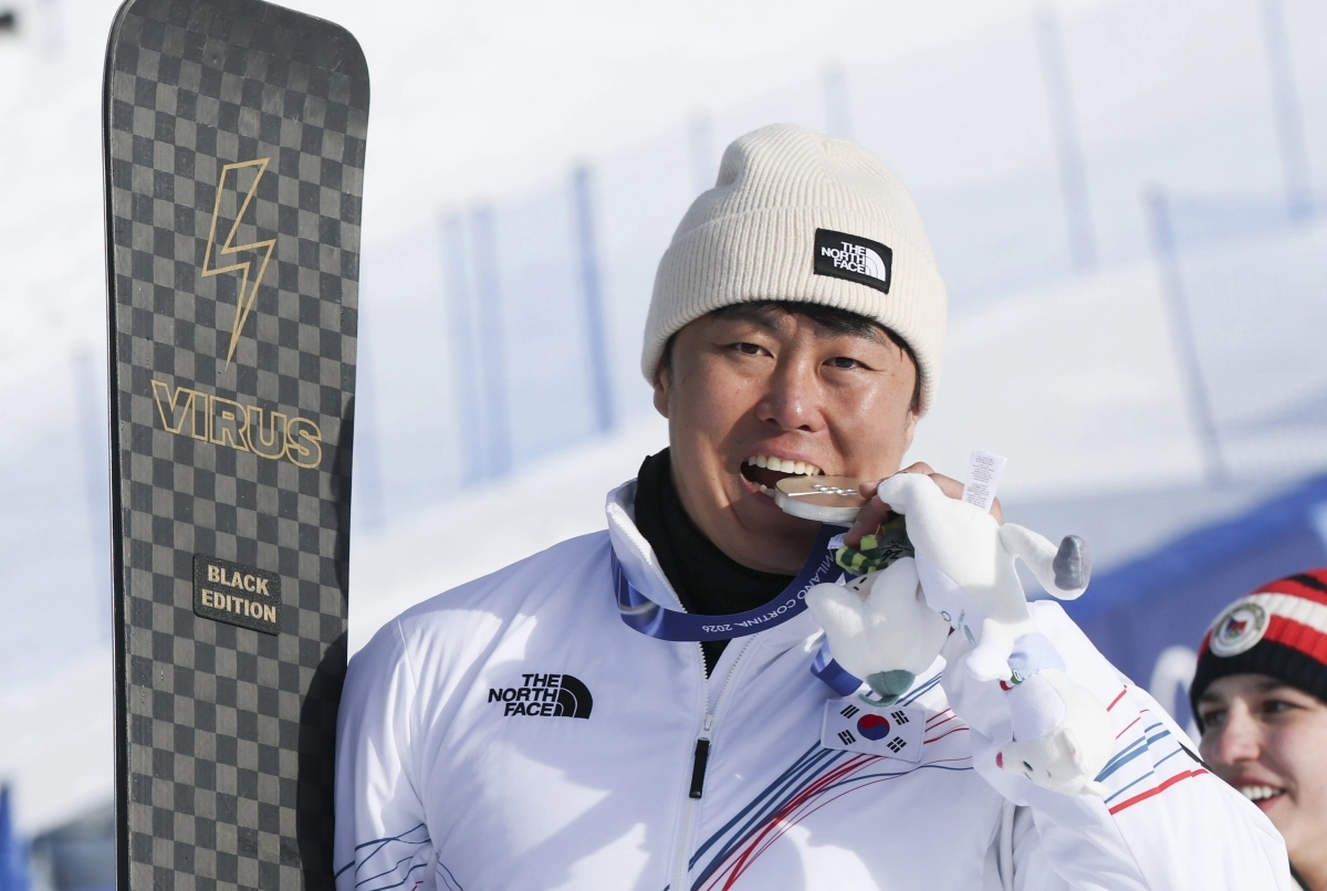 스노보드 은메달리스트 김상겸이 8일(현지 시간) 이탈리아 리비뇨 스노우파크에서 열린 2026 밀라노코르티나 담페초 동계올림픽 스노보드 남자 평행대회전 메달 시상식에서 은메달을 입에다 물고 있다.