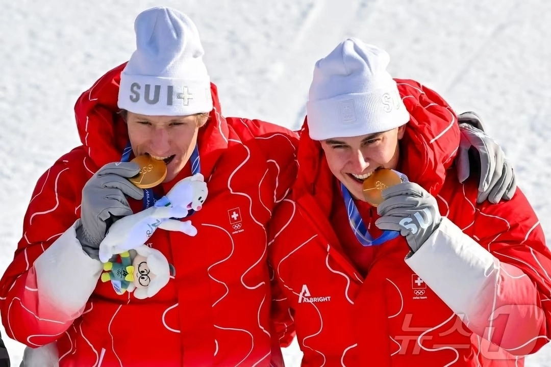 스위스 폰 알멘(오른쪽)과 탕기 네프가 10일(한국시간) 이탈리아 보르미오의 스텔비오 스키 센터에서 열린 알파인 스키 남자 팀 복합 경기에 금메달을 딴 뒤 깨물어보이고 있다.  보르미오 AFP 뉴스1