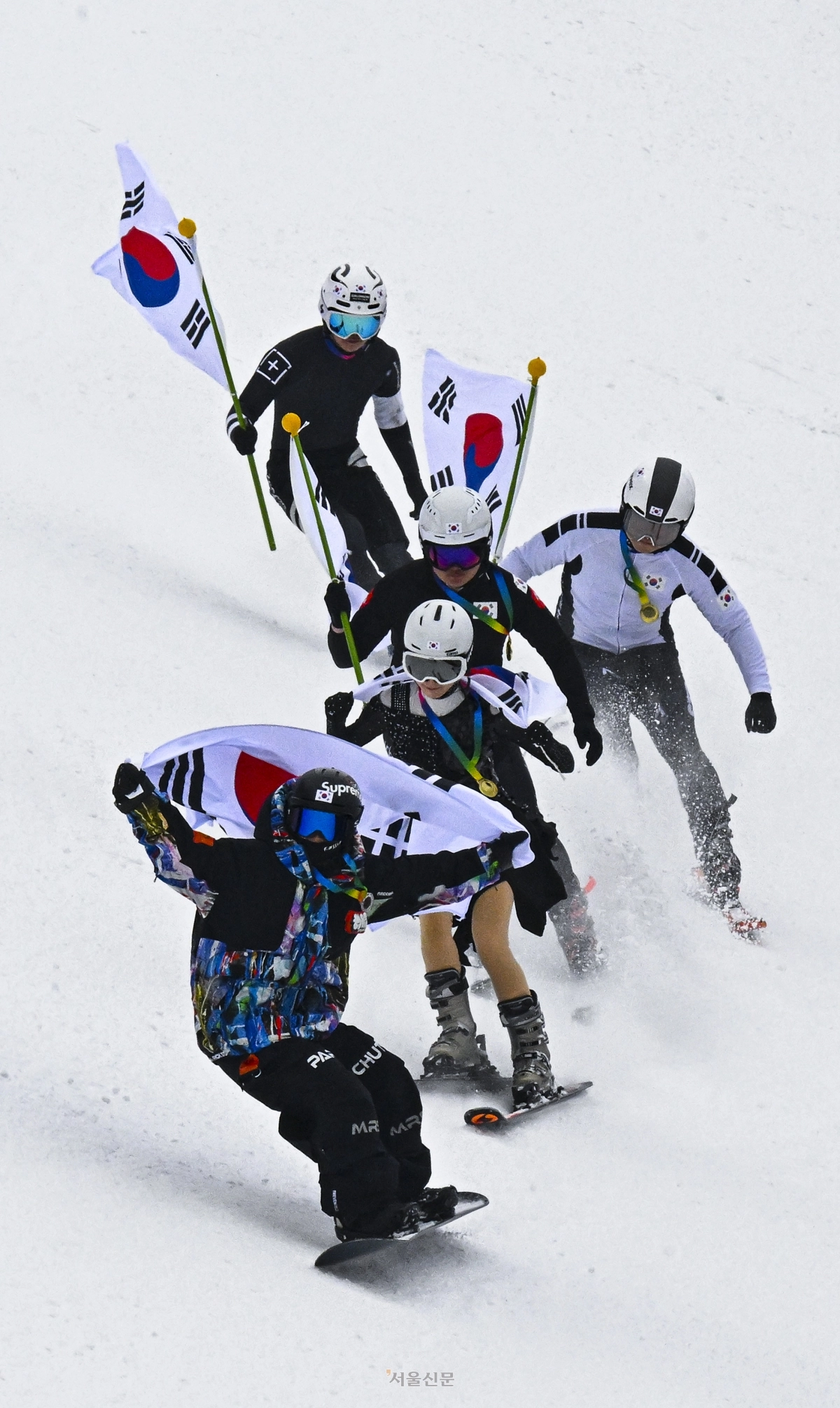 스키어들이 10일 경기 광주시 곤지암리조트 스키장에서 쇼트트랙, 피겨 등의 복장을 차려입고 태극기를 든 채 동계올림픽 국가대표를 응원하는 퍼포먼스를 하고 있다. 2026.2.10 이지훈 기자