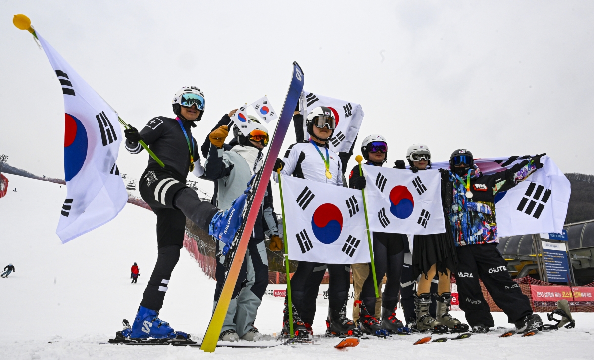 스키어들이 10일 경기 광주시 곤지암리조트 스키장에서 쇼트트랙, 피겨 등의 복장을 차려입고 태극기를 든 채 동계올림픽 국가대표를 응원하는 퍼포먼스를 하고 있다. 2026.2.10 이지훈 기자