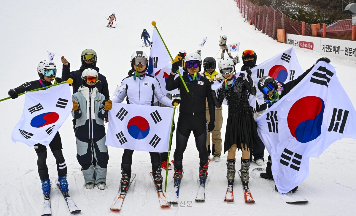 스키어들이 10일 경기 광주시 곤지암리조트 스키장에서 쇼트트랙, 피겨 등의 복장을 차려입고 태극기를 든 채 동계올림픽 국가대표를 응원하는 퍼포먼스를 하고 있다. 2026.2.10 이지훈 기자