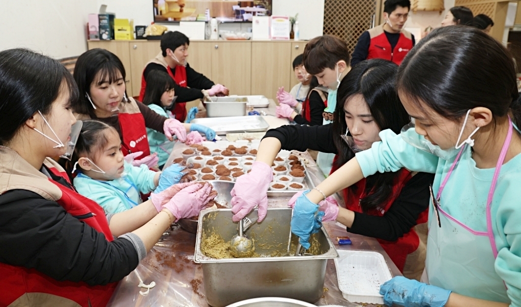 롯데홈쇼핑 임직원이 ‘두쫀쿠 쿠킹클래스’에서 아이들을 도와 속재료를 넣고 있다. 롯데홈쇼핑 제공