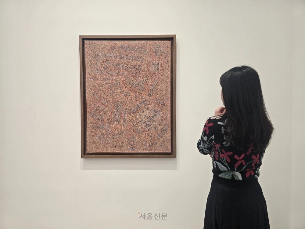 이성자 화백의 1964년 작 ‘5월 단오 No.1’이 전시된 서울 강남구 화이트 큐브를 찾은 한 관람객이 그림을 감상하고 있다.  윤수경 기자