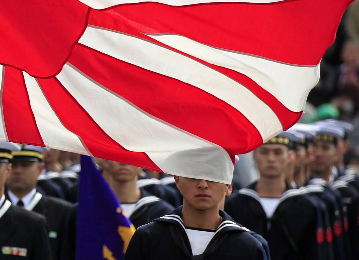 2018년 10월 도쿄 인근 아사카 훈련장에서 열린 자위대 열병식에서 일본 해상자위대 대원들이 욱일기 앞에서 사열을 하고 있다. 서울신문 DB