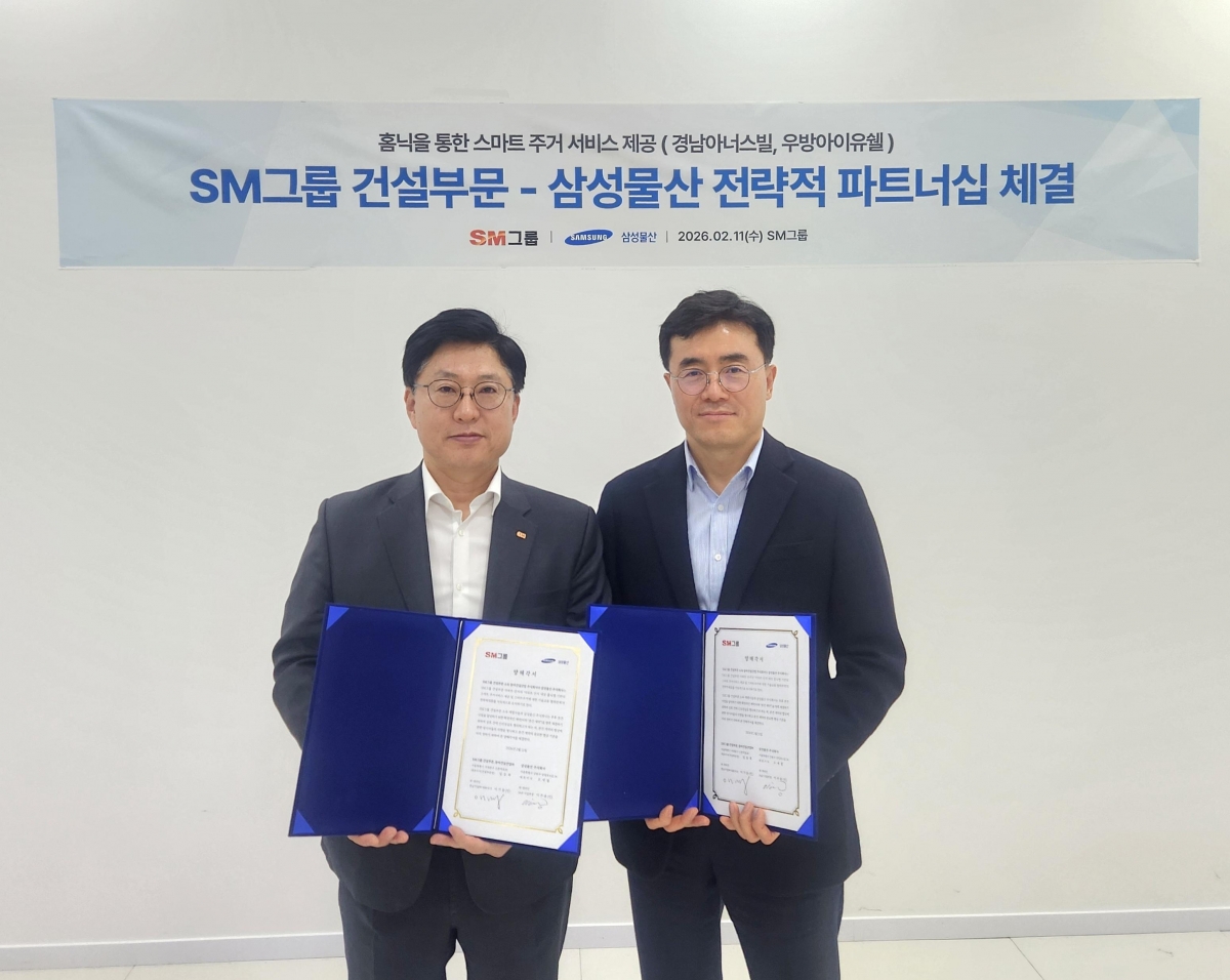 임동복(왼쪽) SM그룹 건설부문장(사장)과 이주용 삼성물산 건설부문 DxP사업부장(부사장)이 지난 11일 서울 서대문구 SM그룹 신촌사옥에서 홈플랫폼 ‘홈닉’을 통한 스마트 주거 서비스 기술교류 협력을 위한 양해각서를 체결한 뒤 기념 촬영을 하고 있다.  SM그룹 제공