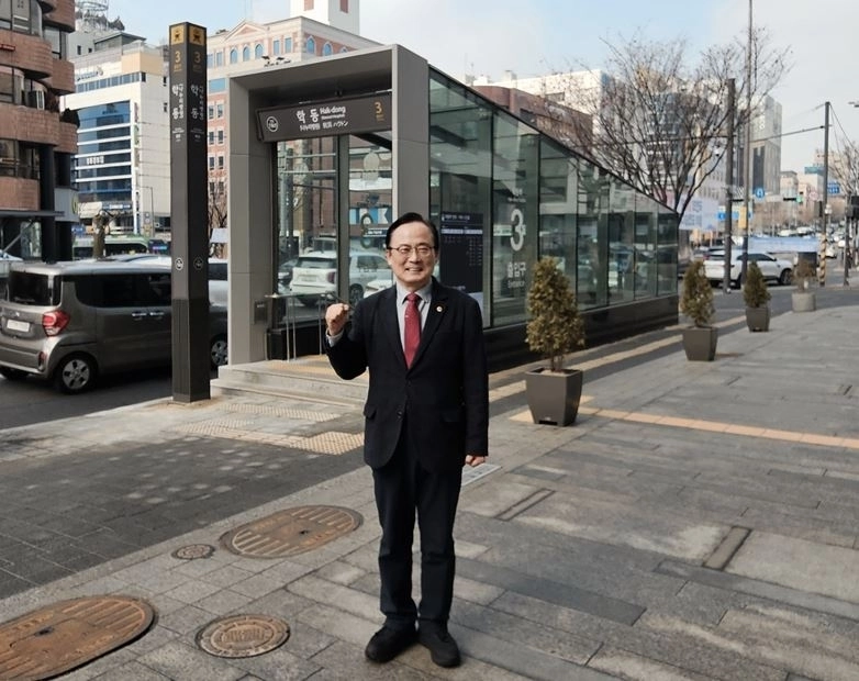 김형재 의원이 학동역 3번 출구 앞에서 캐노피 설치 기념촬영을 하고 있다.