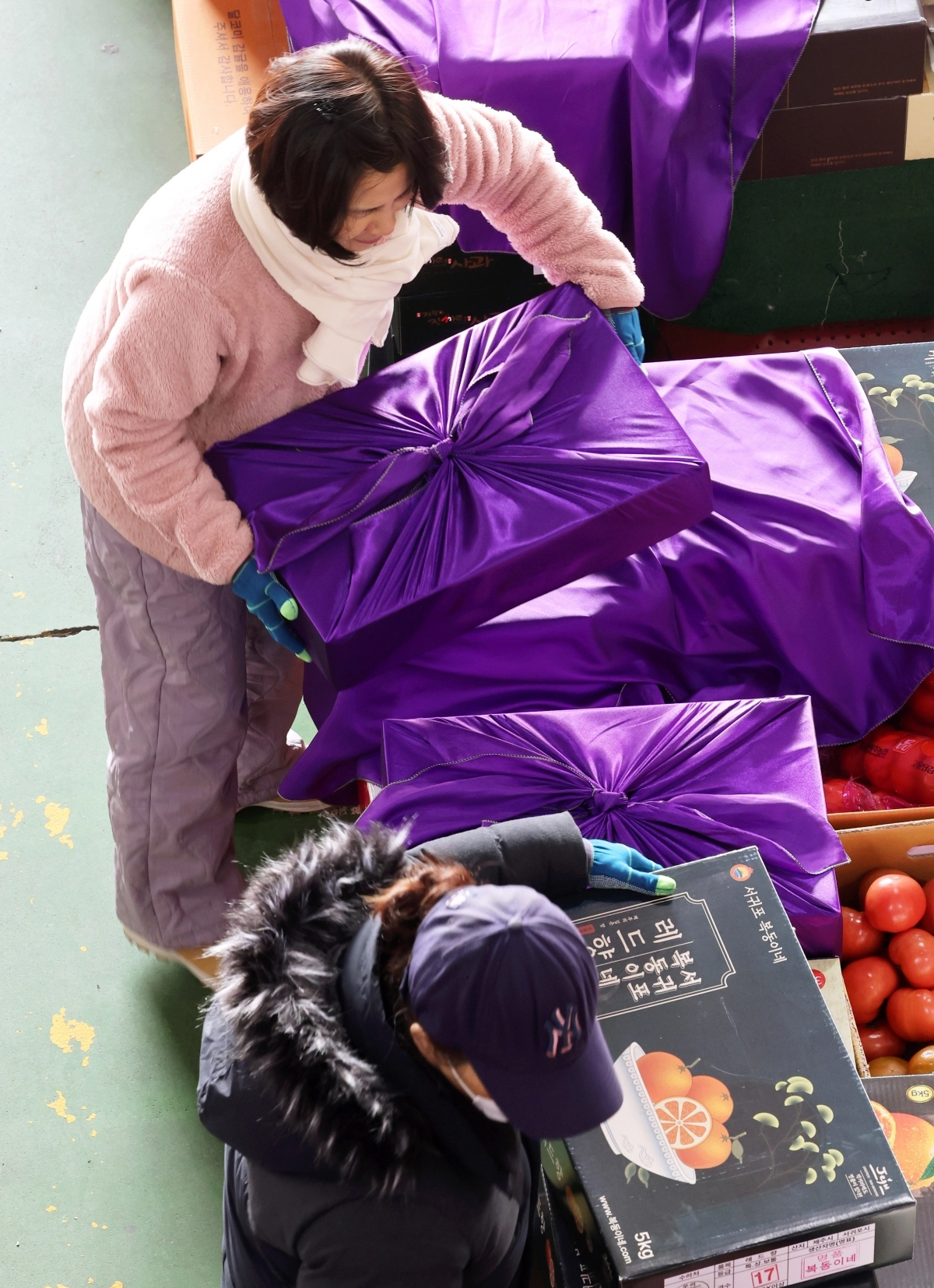 설날을 닷새 앞둔 지난 12일 광주 서구 매월동 서부농수산물도매시장에서 상인들이 선물용 과일상자를 포장하고 있다. 연합뉴스