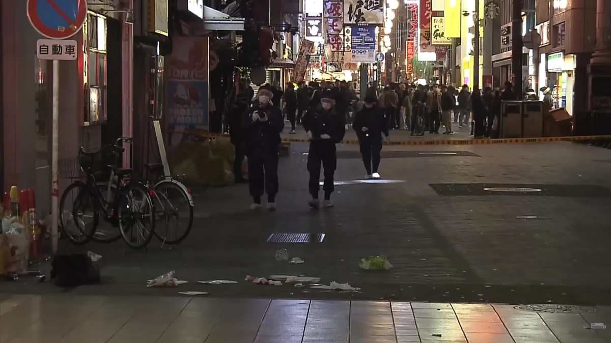 일본 오사카의 최대 번화가인 도톤보리에서 10대 소년 3명이 흉기에 찔려 사망하거나 크게 다치는 사건이 발생했다. 사진은 사건 현장을 살펴보는 수사당국의 모습. TBS뉴스 보도화면 캡처