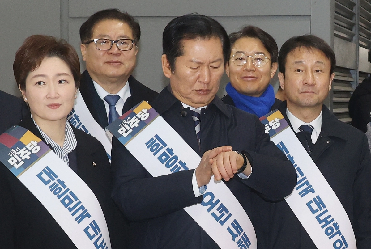 정청래 더불어민주당 대표가 지난 13일 서울 용산구 용산역에서 설 명절 귀성 인사 중 시간을 확인하고 있다. 뉴시스