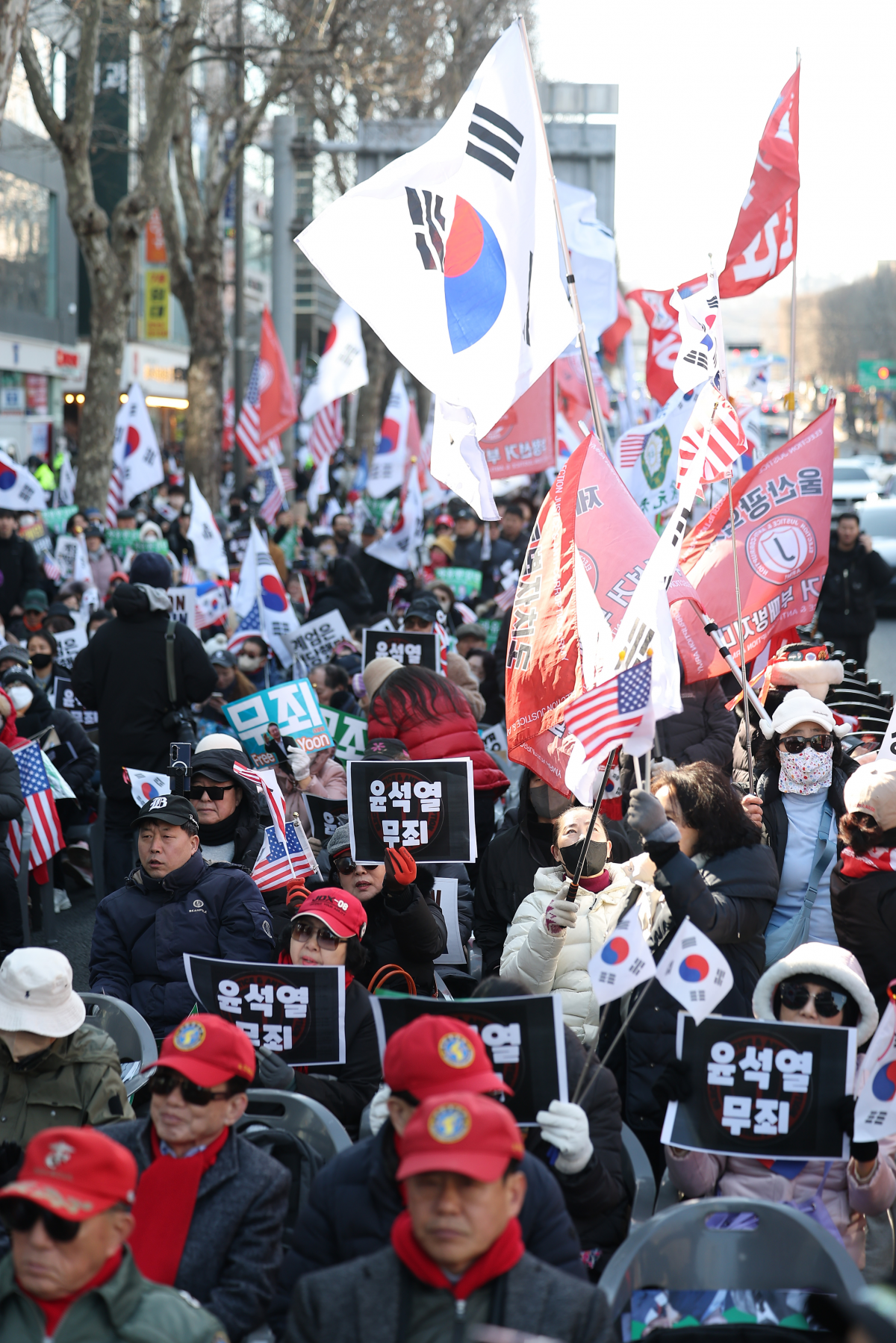 내란 우두머리 혐의로 기소된 윤석열 전 대통령의 1심 선고가 열리는 19일 서울 서초구 서울중앙지방법원 인근에서 지지자들이 “윤석열 무죄” 손팻말을 들고 있다. 연합뉴스