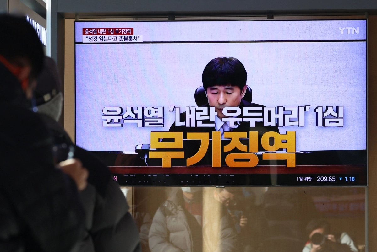 19일 오후 서울 용산구 서울역에서 시민들이 ‘내란 우두머리 혐의’ 윤석열 전 대통령의 1심 선고 공판 중계를 시청하고 있다.  윤 전 대통령은 1심에서 무기징역을 선고 받았다. 뉴시스