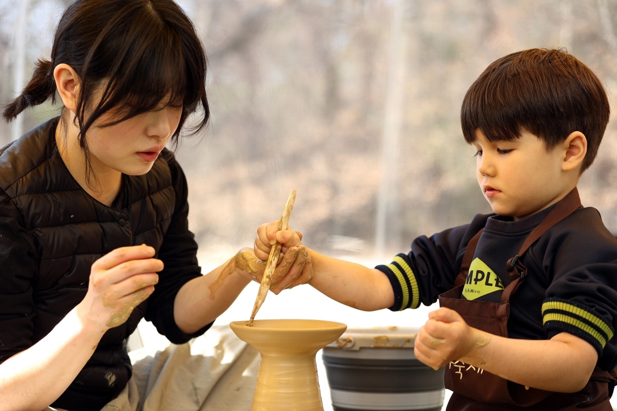 축제장을 찾은 어린이들이 고사리 손으로 물레성형 체험을 하며 정성스레 자기를 빚고 있다.